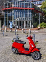 Red Vespa parked in front of the entrance to the Einstein Center for Mathematics building at the