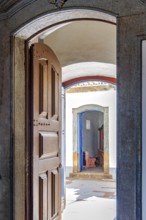Open Baroque church door overlooking the courtyard and entrance to a chapel in Congonhas
