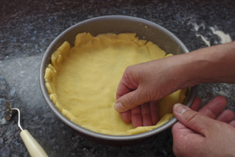 Southern German cuisine, preparation shortcrust pastry, put raw dough in the baking pan, press