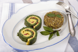 Southern German cuisine, polenta spinach roulade with alblentils served on serving platter, bay