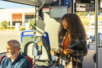 Young woman smiling while validating her transit card on a public bus, traveling in a city