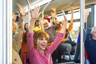 Diverse group of smiling passengers celebrating and cheering with arms raised inside a public