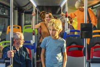 Young boy standing in a bus while other diverse passengers are commuting, experiencing urban public
