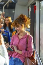 Young woman with red curly hair traveling by bus and checking her smartphone, connecting,