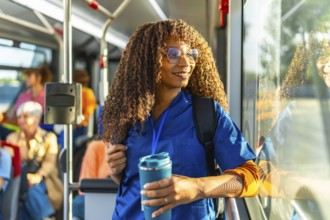 Young black woman nurse wearing blue scrubs and carrying a backpack, happily commuting to work on a