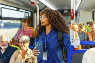 Young woman nurse in medical scrubs carrying a backpack and holding a reusable coffee cup,