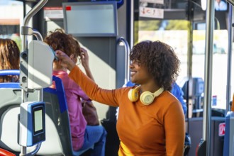 Smiling woman with headphones validating a contactless travel card on a modern electronic validator