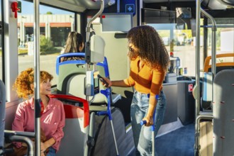 Woman with crutches paying for public transportation using smartphone at the ticket validator,