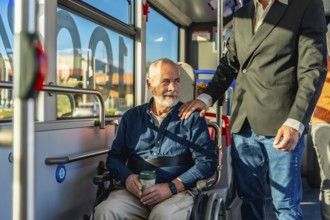 Senior man with a disability using public transportation, sitting in his wheelchair on a bus while