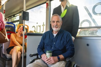 Happy senior man smiling at camera while traveling on a public bus, holding a reusable cup,
