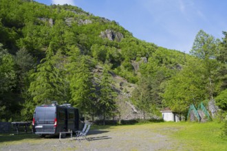 Motorhome is parked on an area in a mountainous and wooded area, free-standing near Purtio,