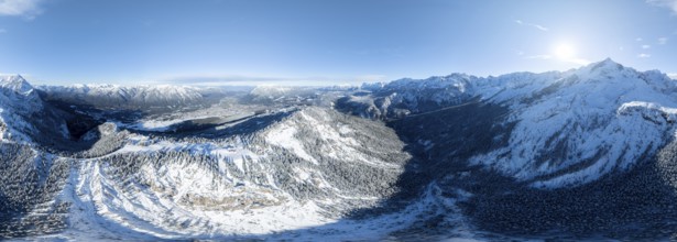 Wonderful winter landscape with Zugspitze, blue sky and snow, mountains and mountain valley, aerial