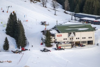 Many snow groomers at the mountain station of the Hochbrixen gondola lift in winter, Skiwelt Wilder