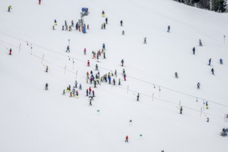Ski lessons and many skiers on a ski slope with drag lift, view from above, Hochbrixen in winter,