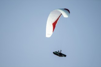 Paragliders flying against a blue sky, Tyrol, Austria