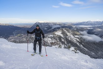 Happy ski tourer climbing to Längenfelderkopf, view of mountain landscape in winter, Wetterstein