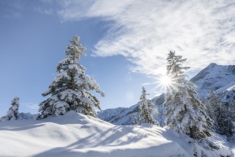 View of snowy mountain landscape with Alpspitz mountain peak, with sun star, ascent to