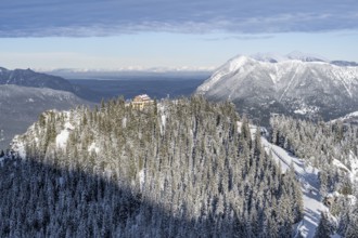 Snowy forest and Kreuzeckhaus mountain hut in the Garmisch Classic ski area in winter, at the back