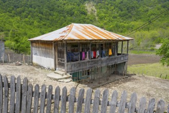 Old wooden house with veranda and colorful laundry, rural area, Imereti region, Imereti, Georgia