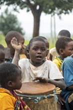 Child playing music with a drum in a Sadaani village, Tanga, Tanzania