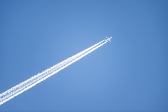 Airplane against blue sky with kondes strips, Tyrol, Austria