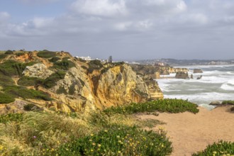 Cliff landscape on a seashore with cloudy sky and rough sea, Algarve, Portugal