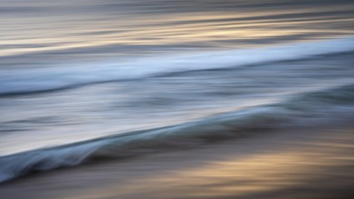Sea waves in the evening light. Long exposure with ICM (Intentional Camera Movement), blurred