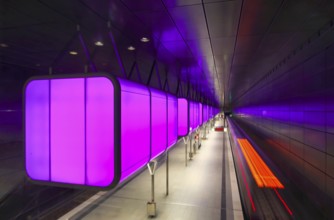 HafenCity University underground station, illuminated in color, magenta, underground train, motion