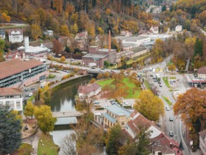 City view with river and bridges in autumn color scheme, surrounded by trees and roads, Calw, Black