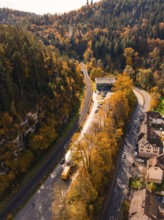 Aerial view of a winding road through an autumnal forest, Calw, Black Forest, Germany