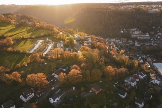 Sunset over a landscape with houses, trees and a parking lot, in autumn, Calw, Black Forest,