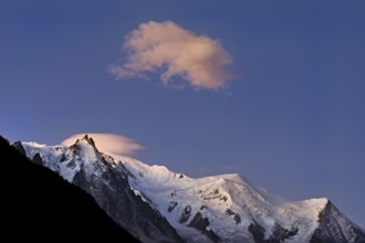 Aiguille du Midi snow-covered from left with sun-lit cloud over the summit, Mont-Blanc, Vallot Hut,