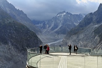 A group of people take pictures of themselves on the viewing platform in front of the Mer de Glace