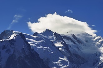 From left snow-covered Mont Blanc du Tacul, Aiguille du Midi, Mont-Blanc in the clouds,