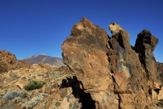 Rough rock formations under clear sky with a volcano in the distance, UNESCO World Heritage Site,