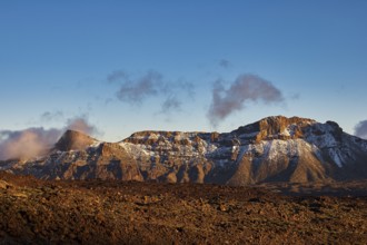 Snowy mountain range under clear blue sky with some clouds, UNESCO World Heritage Site, Teide