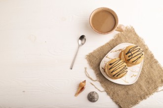 Caramel Cream Cakes on white wooden background and linen textile, cup of coffee, top view, flat