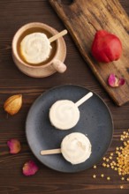 ?hocolate Ice cream in white glaze, cup of coffee, on brown wooden background, top view, flat lay,