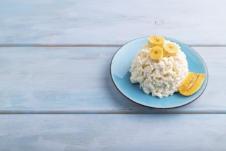 White ?ottage cheese, Curd, with Banana on blue wooden background, side view, copy space
