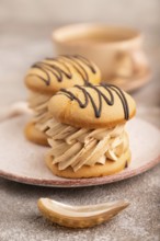 Caramel Cream Cakes on brown concrete background, cup of coffee, side view, close up, selective