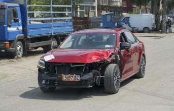 Close-up of red car with frontal damage on the road, Georgia