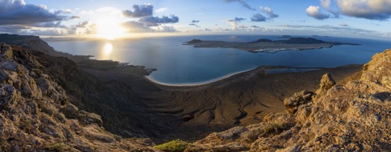 View of steep cliffs to sea and the island of La Graciosa, Mirador del Porrito viewpoint at sunset,