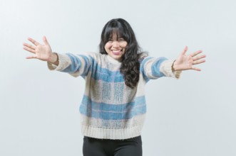 Friendly asian girl welcoming with open arms isolated. Beautiful asian woman welcoming you with