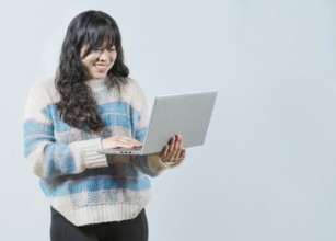 Happy asian girl looking on laptop screen isolated. Portrait of beautiful asian woman using