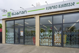 Modern shop front with shop windows and lettered signs in an urban environment, supermarket,