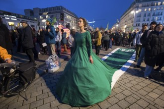 Athena Macke (costume designer) wears a dress with a long train in the shape of a bike path (bike