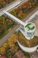 Aerial view of an observation tower with bridge over railroad tracks, surrounded by autumn leaves,