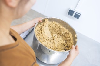Person holding large bowl of dough in kitchen, preparing for baking, Christmas baking, Haselstaller