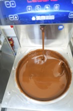 Liquid chocolate is poured into a large container in a machine, Weihnachtsbacken, Haselstaller Hof,