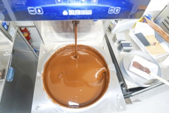 Chocolate machine with liquid chocolate in a commercial kitchen, Christmas baking, Haselstaller